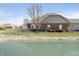 Backyard view of a house with a pond, lush greenery, and beautiful landscaping at 2811 Grandview Ln, Greenwood, IN 46143
