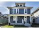 Charming blue two-story home with white trim, inviting front porch and landscaped yard at 404 N Gray St, Indianapolis, IN 46201