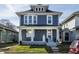Charming blue two-story home with white trim, inviting front porch and landscaped yard at 404 N Gray St, Indianapolis, IN 46201