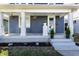Inviting front porch with classic columns, fresh flowers, and manicured landscaping at 404 N Gray St, Indianapolis, IN 46201