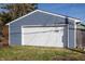 Exterior view of a detached garage with blue siding and a white door at 404 N Gray St, Indianapolis, IN 46201