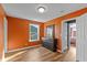 Bedroom with orange walls, featuring wood floors, a black dresser, and a window at 7414 Glen Park Way, Indianapolis, IN 46259