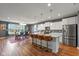 Modern open-concept kitchen with island, stainless steel appliances, and breakfast bar seating at 7414 Glen Park Way, Indianapolis, IN 46259
