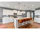 Bright kitchen features a center island with marble countertops, pendant lighting, and stainless appliances at 7414 Glen Park Way, Indianapolis, IN 46259