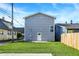 Backyard with a well-maintained lawn and a gray exterior featuring a door and a window at 1446 E Naomi St, Indianapolis, IN 46203