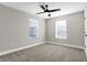 Simple bedroom with grey carpet, window, and ceiling fan at 1446 E Naomi St, Indianapolis, IN 46203