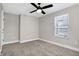 Simple bedroom with grey carpet, window, and ceiling fan at 1446 E Naomi St, Indianapolis, IN 46203