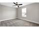 Empty bedroom with grey carpet, ceiling fan, and a window at 1446 E Naomi St, Indianapolis, IN 46203