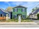 Charming two-story home featuring a vibrant green exterior with black shutters and a well-maintained front yard at 1446 E Naomi St, Indianapolis, IN 46203