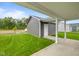 The backyard shows lush green grass, a single-car garage, and a concrete path at 1713 Real St, Indianapolis, IN 46240