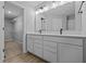 Bathroom with a double sink vanity, quartz countertops, and black faucets, with a glimpse into a walk-in closet at 1713 Real St, Indianapolis, IN 46240