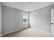 The bedroom includes neutral carpeting, light gray walls, and window at 1713 Real St, Indianapolis, IN 46240
