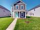 Charming two-story home with a well-manicured lawn and a welcoming turquoise-colored front door at 1713 Real St, Indianapolis, IN 46240