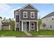Charming two-story home with gray siding, white trim, a quaint porch and lush green lawn at 1713 Real St, Indianapolis, IN 46240