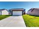 Two story home with attached two car garage, a concrete drive, and a manicured front yard at 1713 Real St, Indianapolis, IN 46240