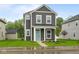 Charming two-story home with gray siding, white trim, and a welcoming turquoise front door at 1713 Real St, Indianapolis, IN 46240