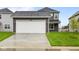 Exterior view of home showing a two-car garage, gray siding, and well-manicured lawn at 1713 Real St, Indianapolis, IN 46240