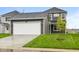 View of house highlighting two-car garage, gray siding, and a nicely landscaped lawn at 1713 Real St, Indianapolis, IN 46240