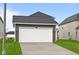Exterior view of an attached two-car garage with driveway and lawn at 1713 Real St, Indianapolis, IN 46240