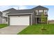 Exterior view of the attached two-car garage with a driveway and green lawn at 1713 Real St, Indianapolis, IN 46240