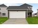 Exterior view of an attached two-car garage with driveway and lawn at 1713 Real St, Indianapolis, IN 46240