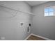 Laundry room with overhead wire shelf, hookup connections and light vinyl flooring at 1713 Real St, Indianapolis, IN 46240