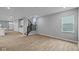 Spacious living room featuring hardwood floors, neutral paint, a staircase, and a large window at 1713 Real St, Indianapolis, IN 46240