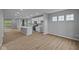 An open floorplan features wood-look floors and neutral paint. The kitchen island has pendant lighting and the kitchen is modern at 1713 Real St, Indianapolis, IN 46240