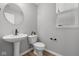 Clean powder room featuring a pedestal sink, elongated toilet, and a decorative mirror above the sink at 1713 Real St, Indianapolis, IN 46240