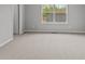 Neutral bedroom with plush carpeting, a large window, and a classic baseboard trim throughout at 1717 Real St, Indianapolis, IN 46240