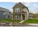 Two-story home showcasing an inviting covered front porch and a well-manicured lawn at 1717 Real St, Indianapolis, IN 46240