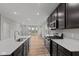 Modern open-concept kitchen featuring stainless steel appliances, granite counters, and a breakfast bar overlooking the living room at 1717 Real St, Indianapolis, IN 46240