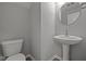 The powder room features a pedestal sink and round mirror at 1721 Real St, Indianapolis, IN 46240