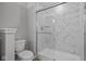 Modern bathroom featuring a marble-tiled shower with glass doors and a white toilet at 1721 Real St, Indianapolis, IN 46240