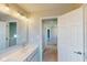 Bathroom vanity with modern faucet and lighting, offering a view to the hallway and carpeted stairs at 1721 Real St, Indianapolis, IN 46240