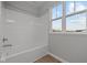 Full bathroom with tub and shower featuring a large window at 1721 Real St, Indianapolis, IN 46240
