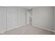 Bedroom showing two closets, neutral carpet, white trim, with a door leading to the landing at 1721 Real St, Indianapolis, IN 46240
