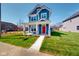 Inviting two-story home featuring blue siding, white trim, a red front door, and a neatly landscaped front yard at 1721 Real St, Indianapolis, IN 46240
