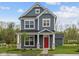 Charming two-story home featuring a striking red door, stone accents, and beautiful curb appeal at 1721 Real St, Indianapolis, IN 46240