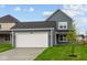 Traditional two-story home with attached two-car garage and dark gray siding at 1721 Real St, Indianapolis, IN 46240
