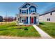 Charming two-story home boasting blue siding, white trim, a red front door, and a well-manicured lawn at 1721 Real St, Indianapolis, IN 46240