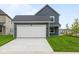 Charming home featuring an attached two-car garage, with lush lawn and picturesque street view at 1721 Real St, Indianapolis, IN 46240