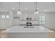 Modern kitchen featuring gray cabinets, quartz countertops, stainless steel appliances, and pendant lighting at 1721 Real St, Indianapolis, IN 46240