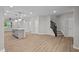 Open-concept living space features wood floors, neutral paint, a kitchen island, and a modern staircase at 1721 Real St, Indianapolis, IN 46240