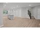 Open living space with a kitchen island, staircase, and wood-look flooring at 1721 Real St, Indianapolis, IN 46240