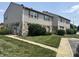 Townhome exterior with stone accents, tidy lawn, and concrete walkway to front door at 2634 Country Estates Dr # 17, Indianapolis, IN 46227
