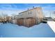 Tan siding home with stone accents and snowy yard at 2634 Country Estates Dr # 17, Indianapolis, IN 46227