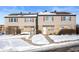 Tan siding duplex with stone accents, snowy front yard, and walkways at 2634 Country Estates Dr # 17, Indianapolis, IN 46227
