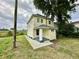 Side view of the house showcasing its yellow siding and landscaping at 2705 Shriver Ave, Indianapolis, IN 46208