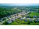 An aerial view displays a tranquil neighborhood surrounded by green space and mature trees at 3460 Limelight Ln, Whitestown, IN 46075